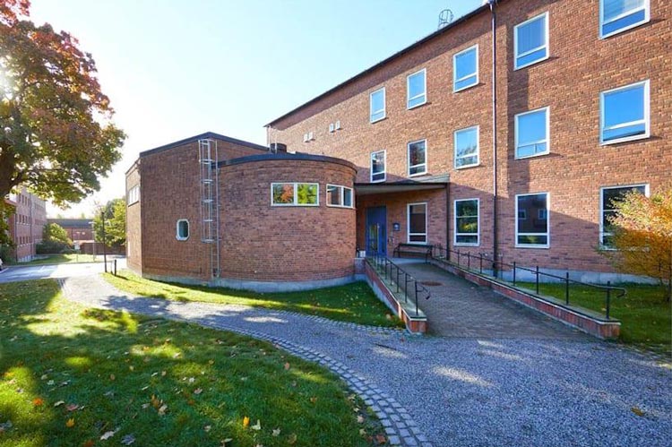 Modern byggnad med ståldörrar och trädörrar, säkerhetslösning vid entrén